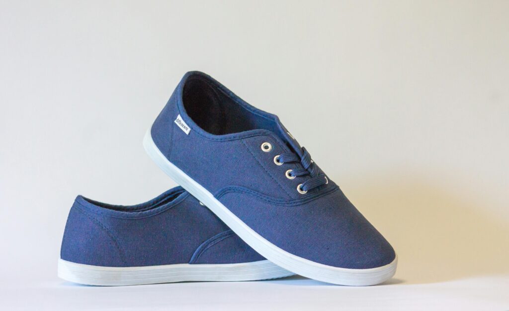 Pair of stylish blue canvas shoes with white soles displayed against a neutral background.